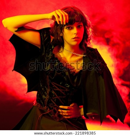 Scary woman in a Halloween costume with bat wings.