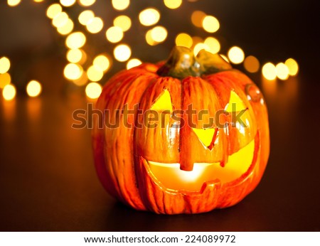 Halloween pumpkin head with beautiful bokeh lights in the background, scary smile. Light inside.