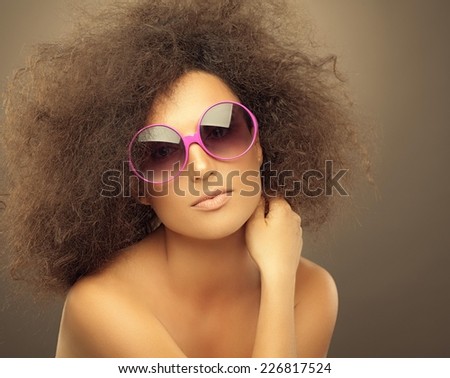 Beautiful woman with afro hair and funny sunglasses posing.
