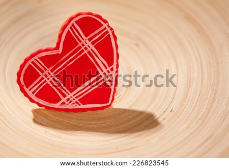 Cute heart shaped Valentine's cookie on a wooden plate.
