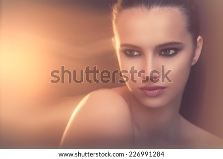 Beautiful woman posing shirtless. Dark background with some motion blur. Long exposure. No effects added in PS.