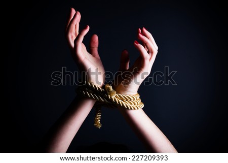 Close up of female hands tied in a rope