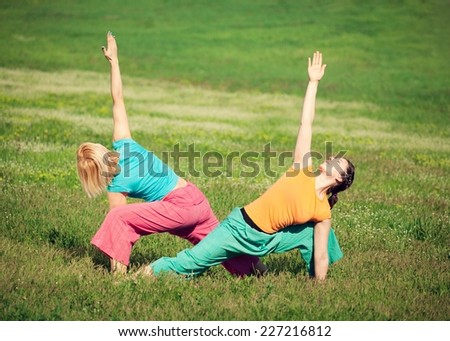 Young women practicing yoga in nature. Triangle pose.