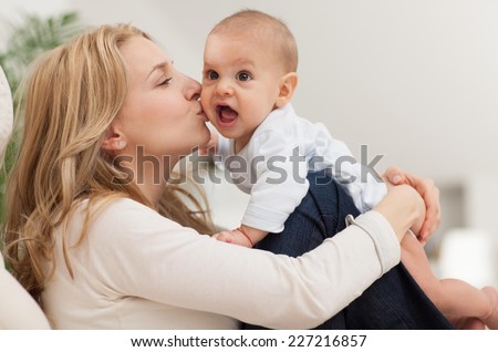 Happy mother kissing her 6 month old son.