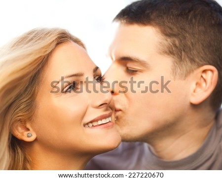 Young couple - man kissing woman on the cheek