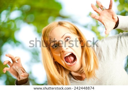 Young woman screaming and jumping from the tree.