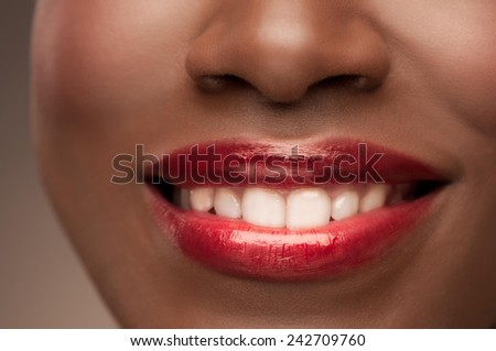 Close up of a beautiful african woman with healthy white teeth smiling. Cropped.