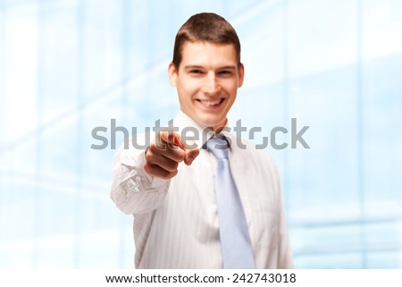 Young smiling businessman pointing with his finger