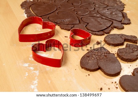 Cutting off heart shapes chocolate cookies and three molds