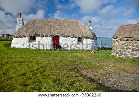 Struan Cottage, Malacleit, North Uist, Scotland. A restored crofters cottage. The thatched roof is weighted down with large stones due to the high winds on the Hebridean Islands