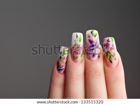 Human fingers with beautiful spring manicure over gray background