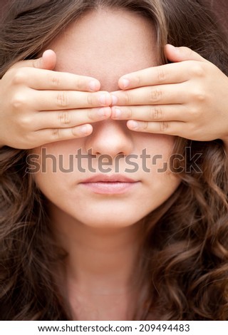 Don\'t look! Younger sister closed eyes of her older sister by hands