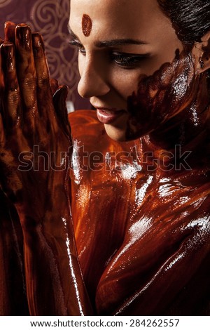 Spa treatments: chocolate body wraps. Woman covered in melted chocolate.