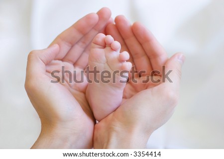 Father gently hold baby\'s leg in your hands