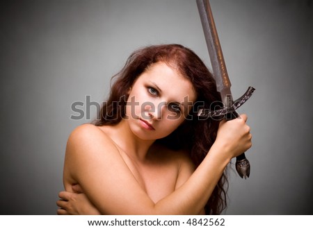 Attractive woman with sword on gray background
