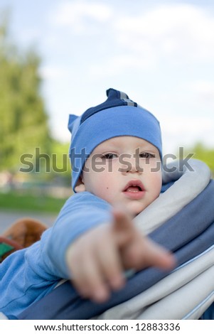 Baby in sitting stroller pointing his finger right at you