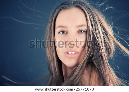 Portrait of attractive girl with fly-away hair on the wind