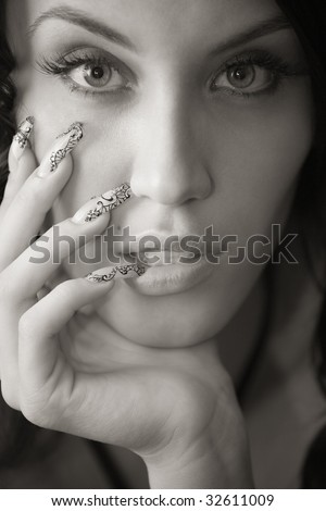 Brown toned portrait of attractive girl with manicure on long nails