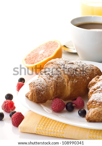 croissant and a cup of coffee and berries on a white background