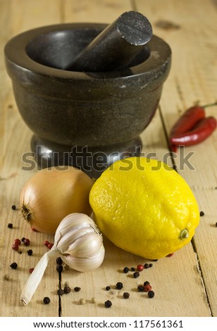 garlic, lemon, onion, marinade ingredients, granite mortar on a wooden board