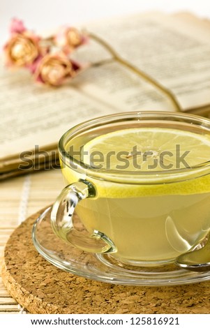 ginger drink with a slice of lemon in a glass cup, drink ginger in a jar, lemon, ginger on a bamboo napkin