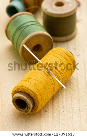 old spools of colored thread on a wooden background