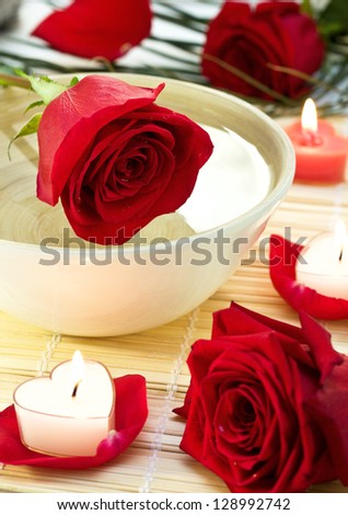 Spa decor with red roses, candles and rose petals