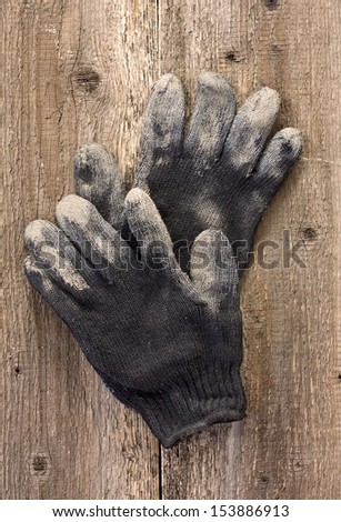 A pair of work gloves on the old wooden background