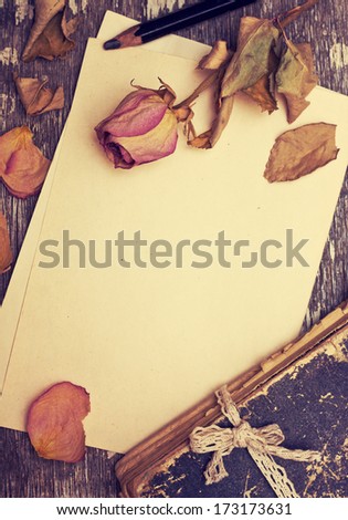 Dry Rose And Old Book On A Wooden Background With Space For Information (Vintage)