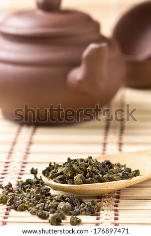 Chinese green tea dry, ceramic teapot on bamboo background