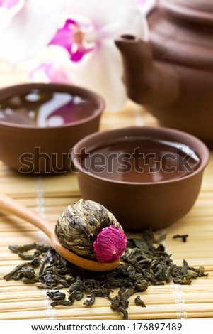 Asian tea set  with Chinese blooming tea, dry green tea on a bamboo background