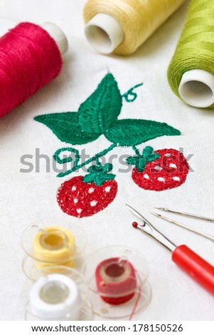 machine embroidery image strawberry, tools for embroidery: thread, needle, bobbin