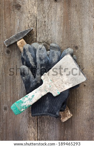 Contaminated gloves, hammer, putty knife on a wooden background