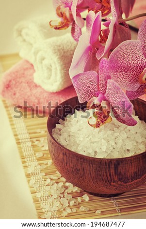 Spa still life with orchid, towel, bath salt on a bamboo napkin in vintage style