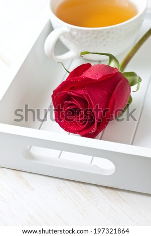 red rose and a cup of tea on a white tray (morning tea)
