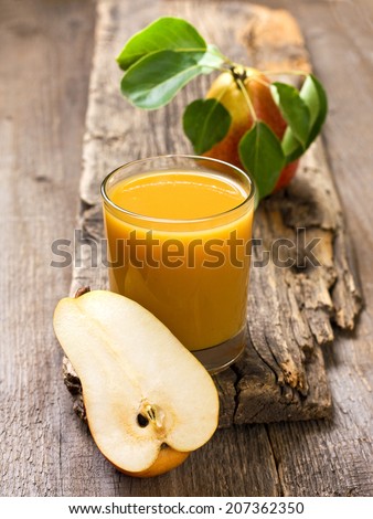 glass of pear juice, pears on old wooden background