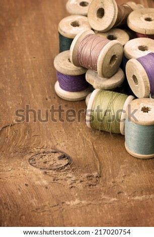 old spool thread on a wooden background (sepia)