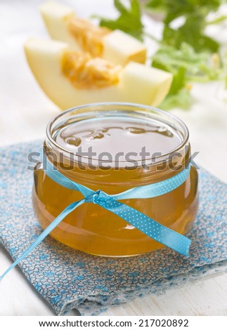 melon jam in a glass jar on a wooden background