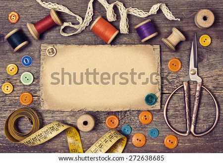 old spools of thread, scissors,  buttons on the old wooden background (toning)