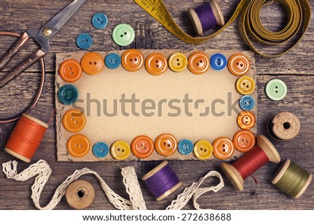 old spools of thread, scissors, buttons on the old wooden background (toning)