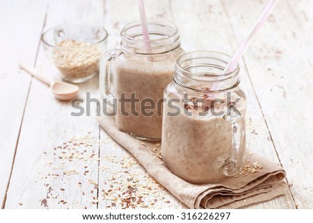 smoothies with  oatmeal,  flax seeds in glass jars on a wooden background