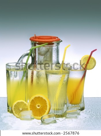 Fresh and cold orange and lemon drink in glass with droplets
