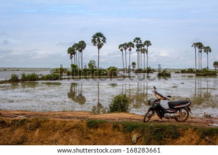 A Motor Bike parked on a levy in the Cambodian Countryside/ Cambodian Countryside/ A local parked his motor bike on the levy during the rainy season not far from Siem Reap Cambodia