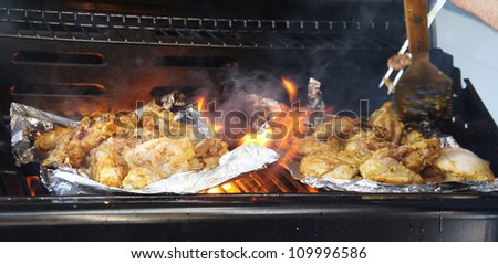 Tandoori chicken cooking on grill makes flames jump up