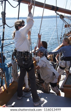 KIRKLAND, WASHINGTON - AUG 31 - The crew rigs the sails of the Hawaiian Chieftain as she sails  during a mock sea battle as part of Labor Day festivities on Aug 31, 2012 near Kirkland , Washington.