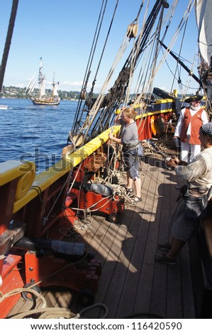 KIRKLAND, WASHINGTON - SEP 1 - The crew sets the sails of the Lady Washington     during a mock sea battle as part of Labor Day festivities on Sep 1, 2012 near Kirkland , Washington.