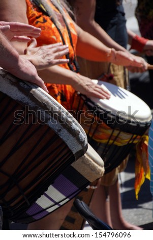 Close up of drumming by woman in bright clothes, Penticton, British Columbia, Canada..
