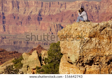 GRAND CANYON, ARIZONA - SEP 28 - Woman photographer taking last pictures at the South Rim before the government shutdown,  on Sep 28, 2013 at the Grand Canyon National Park, Arizona