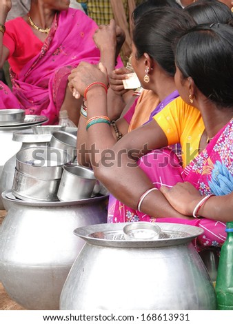 ORISSA,  INDIA - Nov 13 - Tribal women sell home brewed liquor from large metal pots   on Nov 13, 2009, in Orissa, India