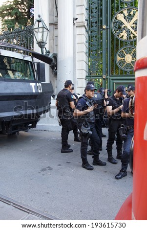 ISTANBUL - MAY 18, 2014 - Police truck with water cannon and officers in riot gear await orders during a protest demonstration near Taksim Square  in Istanbul, Turkey